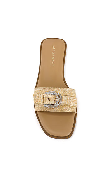 top view of beige flat slip on sandals with a weaved raffia foot band featuring a belted accent on top