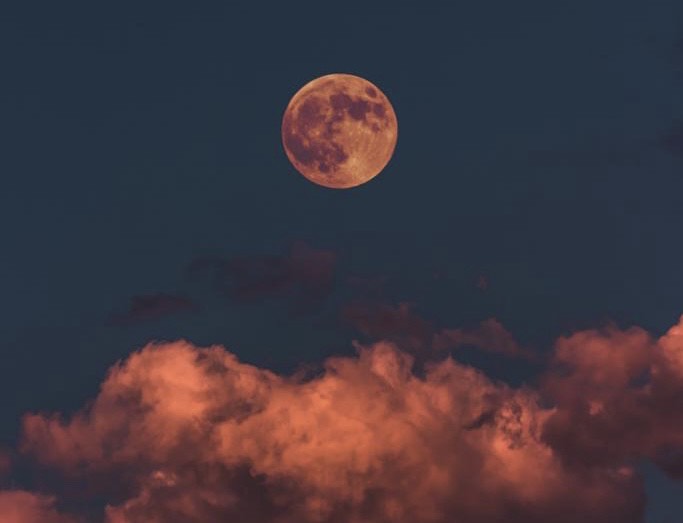 Image of spooky halloween full moon and colorful pink clouds