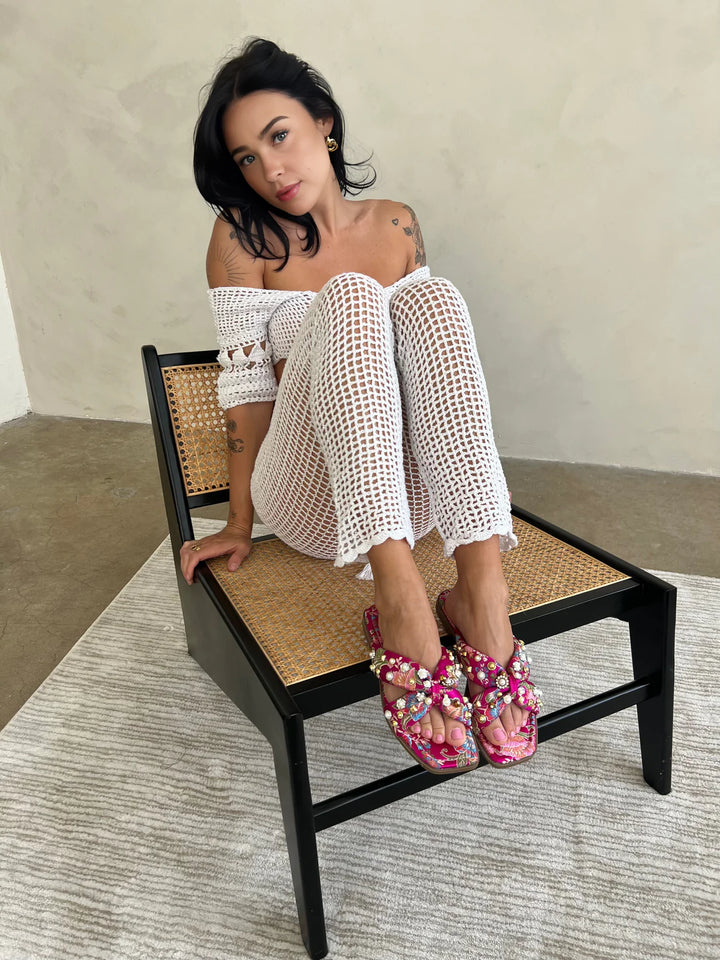 Model wearing pink rhinestone flat sandals for Summer activities