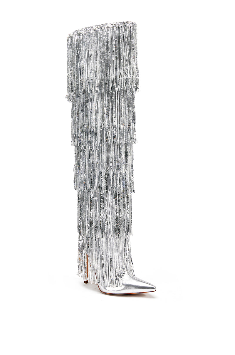 angled view of  silver knee high boots with layers of shiny metallic silver fringe detail on the shaft