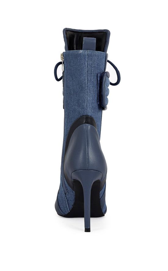 dark wash denim and navy blue faux leather heeled boots with a mid calf length, lace up accent, and velcro belted accent with an inner zip up closure