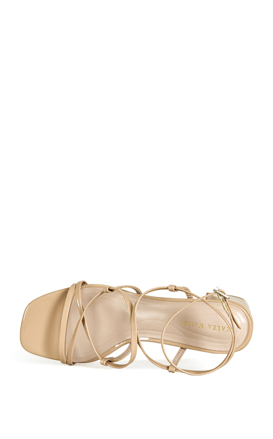 beige faux leather strappy sandals with a square block heel and an adjustable ankle strap