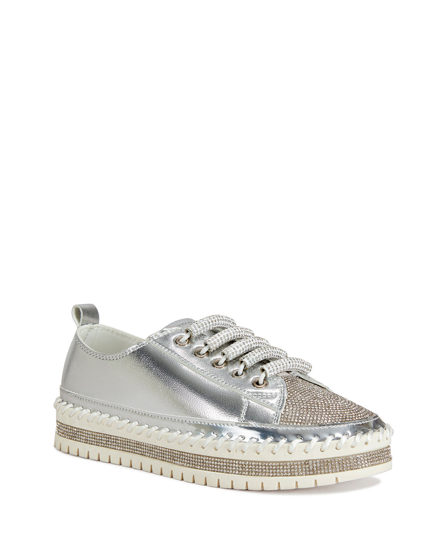 angled view of metallic silver faux leather statement sneakers with a white platform sole and a crystal embellished toe and side of the sole