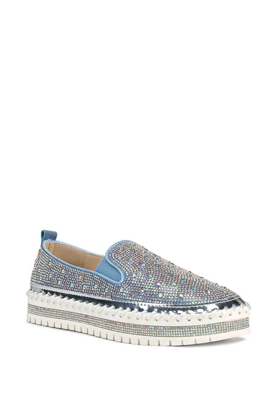 angled view of slip on light wash denim flat sneakers with crystal rhinestone embellishments and a white braided platform sole