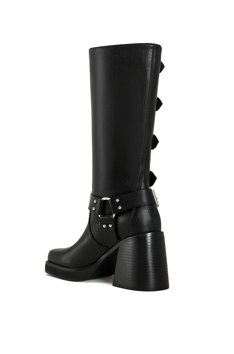 back view of black faux leather moto boot with a black block heel and silver hardware belted accents along the shaft