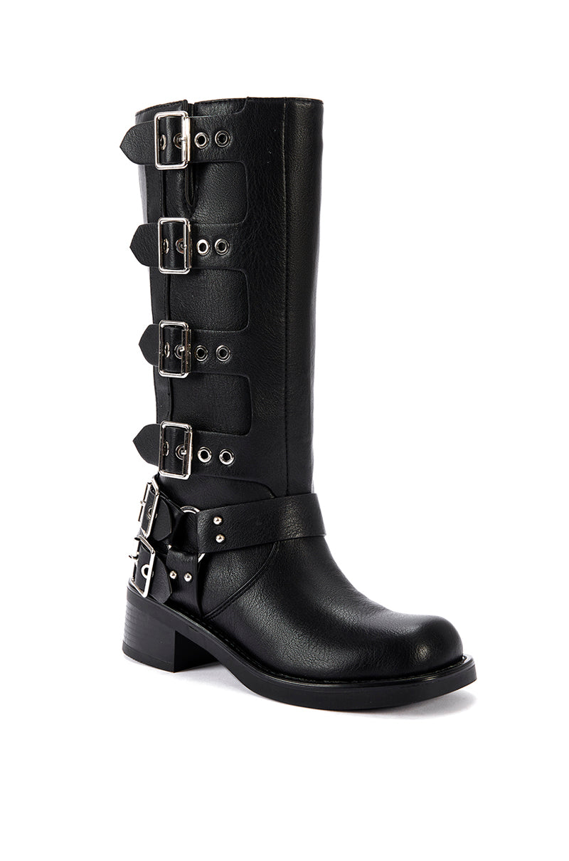 angled view of  mid calf length black faux leather boots with a rounded toe, small block heel, and silver buckle design going up the shoe