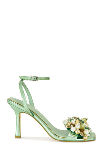 metallic mint green faux leather open toe statement sandals with a stiletto heel, adjustable ankle strap, and faux pearl and seashell embellished foot strap