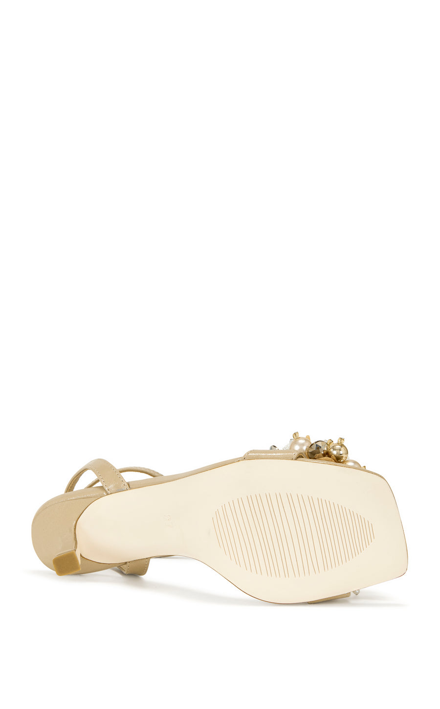 beige faux leather open toe statement sandals with a stiletto heel, adjustable ankle strap, and faux pearl and seashell embellished foot strap