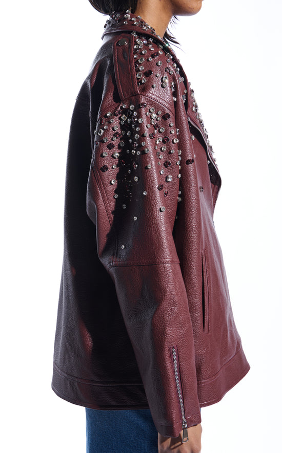 burgundy faux leather statement coat with  an oversized fit, zips on the sleeves, and sparkly rhinestone embellishments on the collar and sleeves