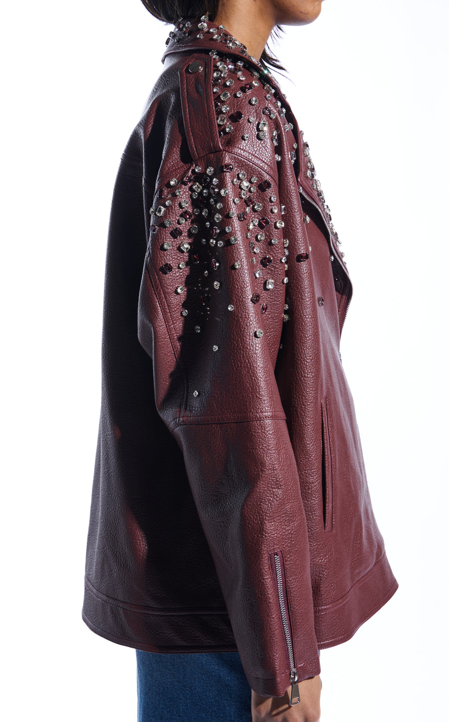 burgundy faux leather statement coat with  an oversized fit, zips on the sleeves, and sparkly rhinestone embellishments on the collar and sleeves