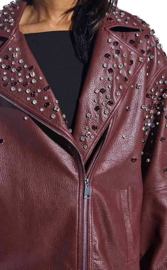 burgundy faux leather statement coat with  an oversized fit, zips on the sleeves, and sparkly rhinestone embellishments on the collar and sleeves
