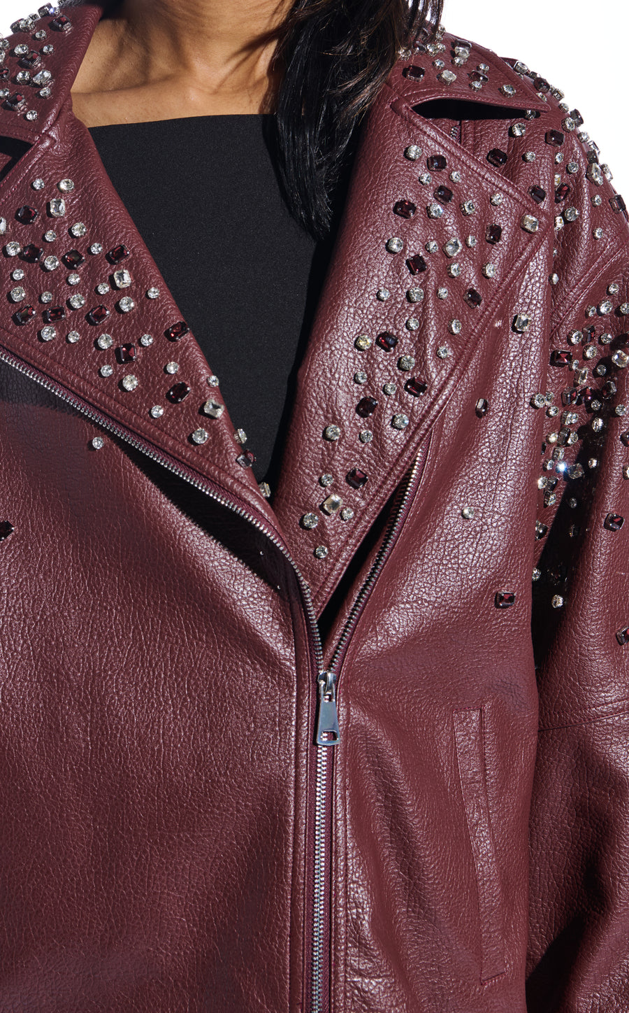 burgundy faux leather statement coat with  an oversized fit, zips on the sleeves, and sparkly rhinestone embellishments on the collar and sleeves
