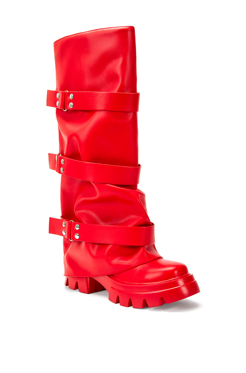 angled view of cherry red platform knee high fold over black faux leather boots with three accent straps on shaft