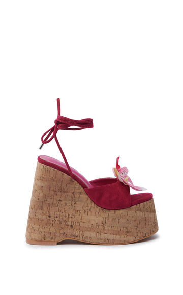 ultra platform heeled wedge sandals with an open toe and fuchsia faux suede upper with an orchid flower accent on the foot strap and two faux suede wrap cords