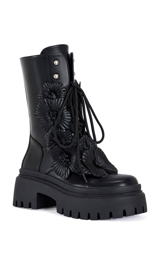 black faux leather mid calf length combat bootie with a chunky platform sole and  black faux leather flower embellishments on the shaft
