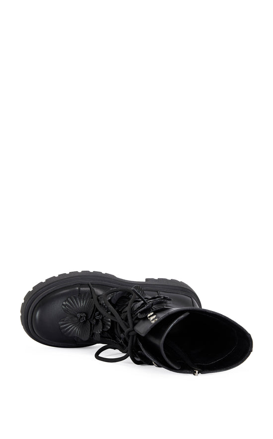 black faux leather mid calf length combat bootie with a chunky platform sole and  black faux leather flower embellishments on the shaft