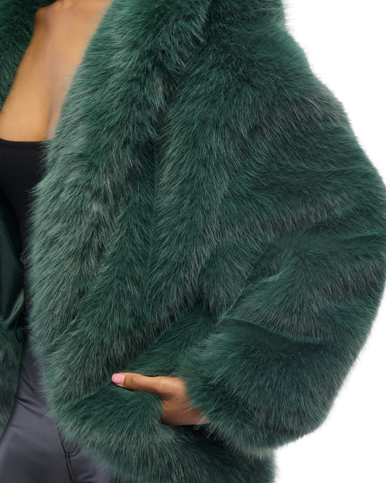 emerald green faux fur statement coat with a high low silhouette and an oversized collar