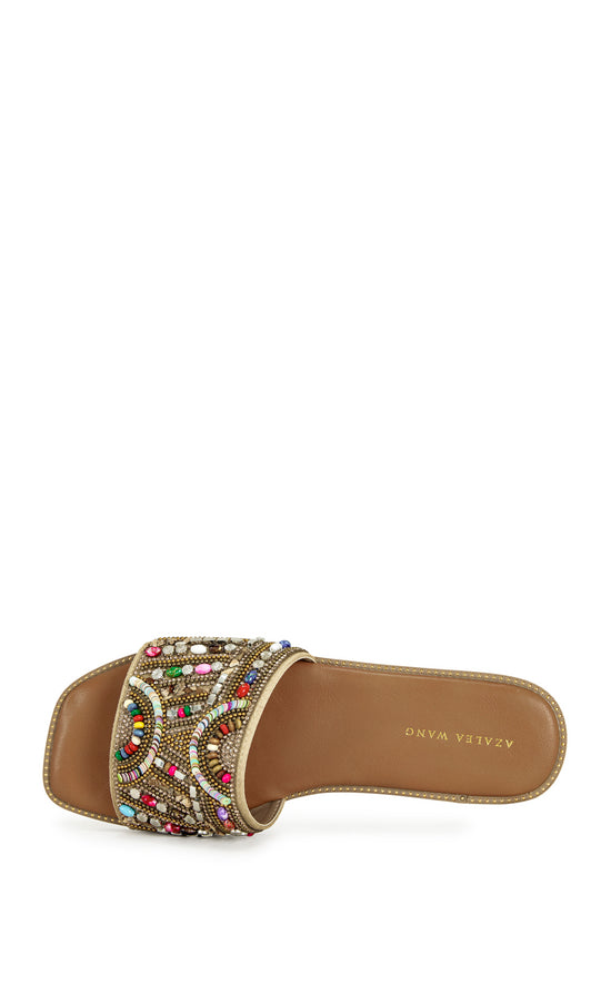 beige faux leather slip on flat sandal with a colorful crystal embellished foot strap