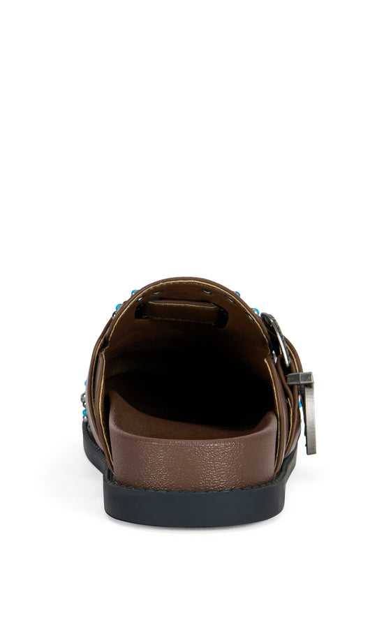 brown faux leather slip on flat mules with a western inspired belted accent with turquoise and stud embellishments