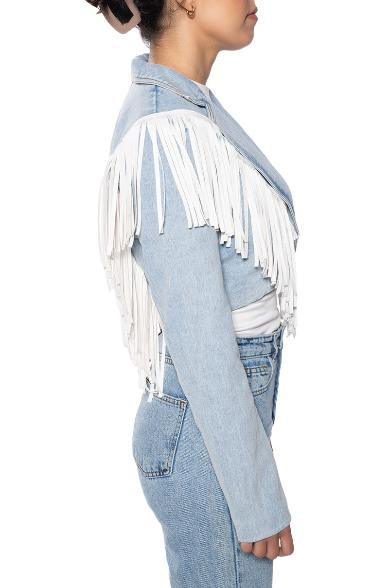 side view of cropped denim western inspired jacket with a sharp collar lined with white fringe
