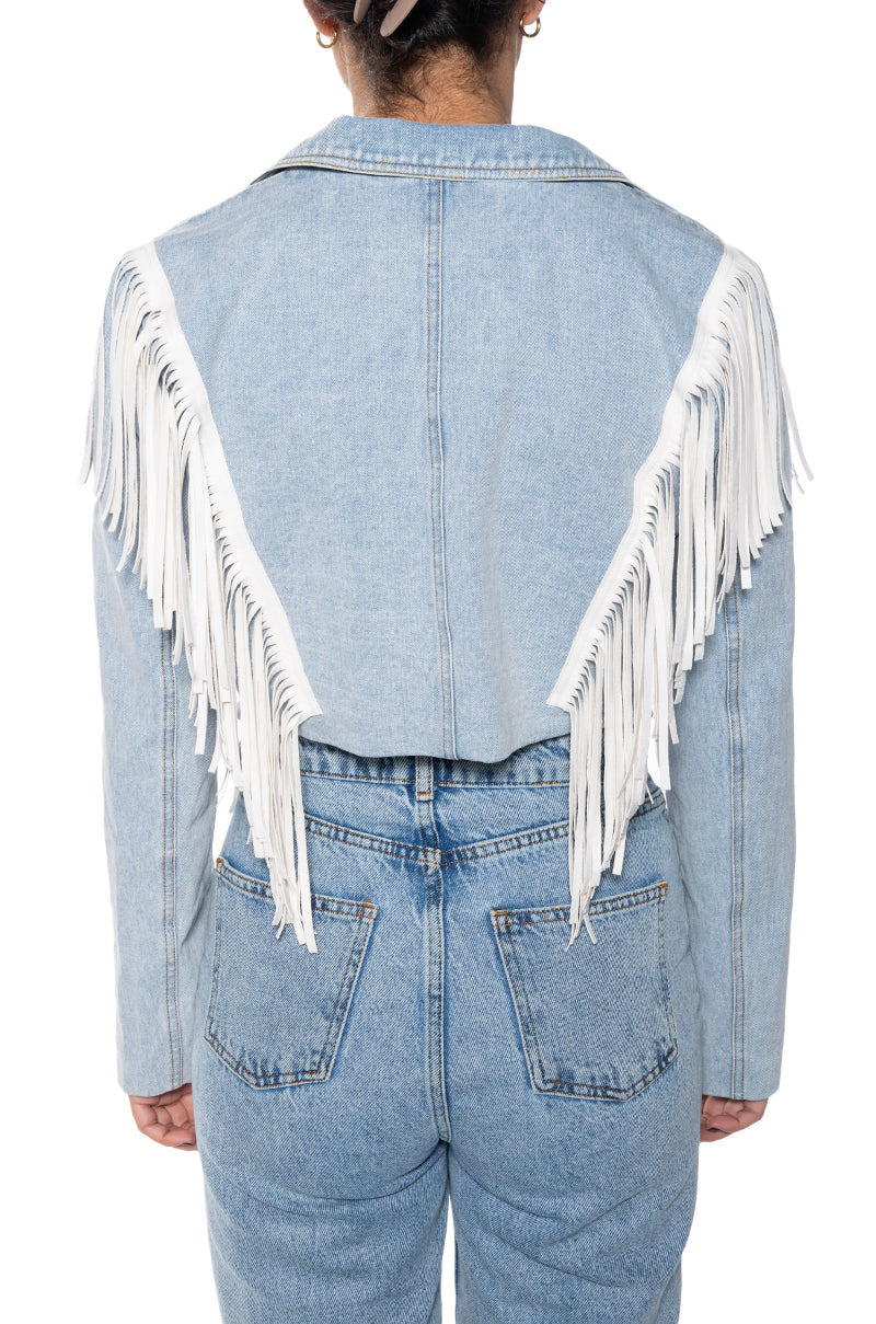back view of cropped denim western inspired jacket with a sharp collar lined with white fringe