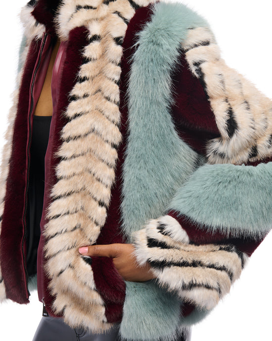 multicolored faux fur statement coat with pale blue, wine red, black, and white color block accents. finished with a zip up closure