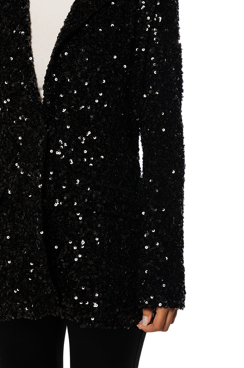 detail shot of shiny black sequin statement jacket with a classic blazer silhouette