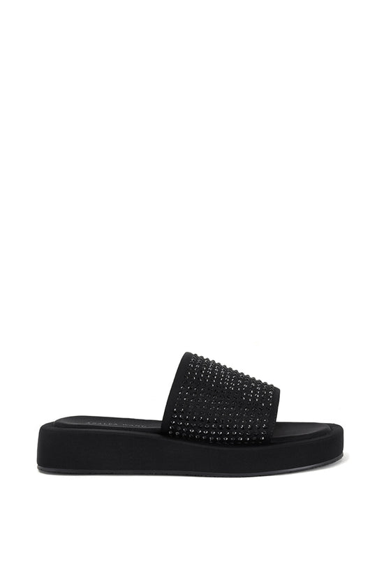 black flat slip on sandal with black rhinestone embellishments on the foot strap