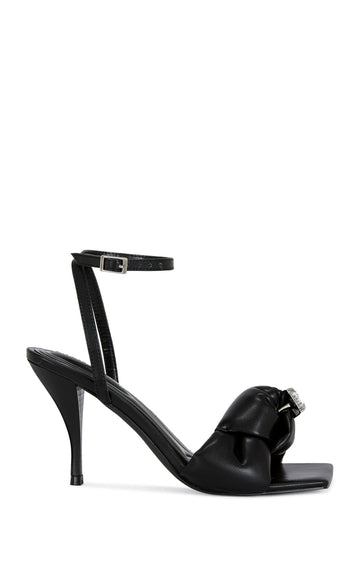 black faux leather open toe heels with a stiletto heel, a knotted foot strap with a rhinestone studded accent, and an adjustable ankle strap