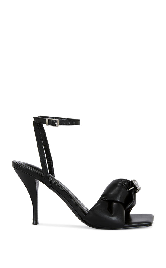 black faux leather open toe heels with a stiletto heel, a knotted foot strap with a rhinestone studded accent, and an adjustable ankle strap