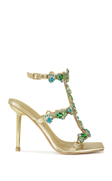 gold faux leather strappy stiletto heels with an open toe construction, adjustable ankle strap, and colorful rhinestone embellishments on the straps.