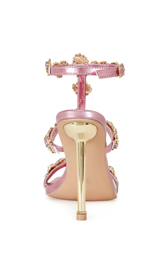 metallic pink faux leather strappy stiletto heels with an open toe construction, adjustable ankle strap, and colorful rhinestone embellishments on the straps.