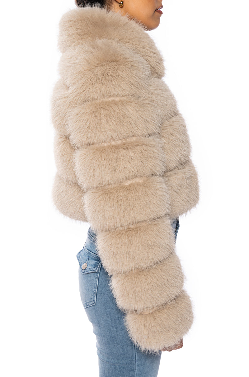 side view of luxurious cropped zip up beige faux fur jacket with accent collar