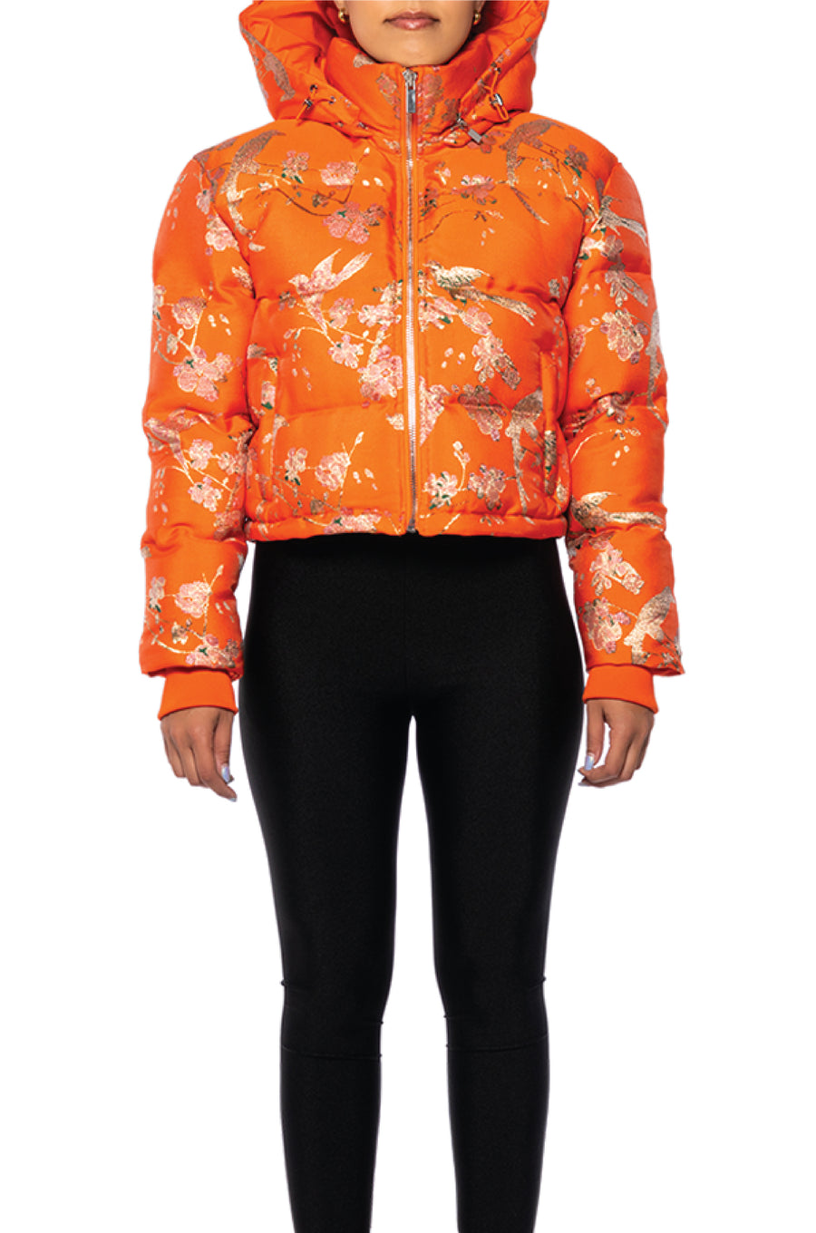 front view of bright orange cropped hooded puffer jacket with floral patterned design