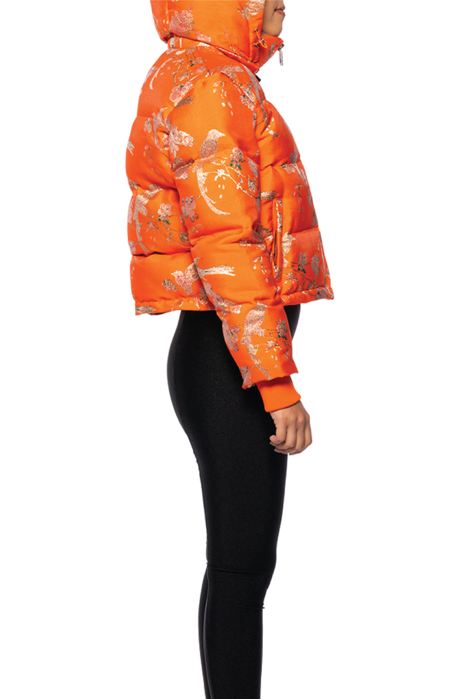 side view of bright orange cropped hooded puffer jacket with floral patterned design