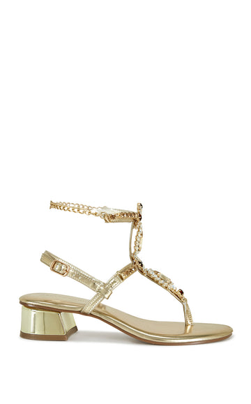 metallic gold faux leather statement sandals with a thong strap embellished with rhinestones, an adjustable ankle strap, and a gold ankle chain