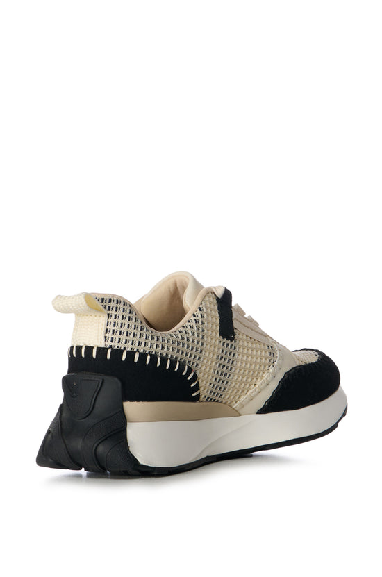 cream lace up sneakers with black stitched accents and a chunky white sole
