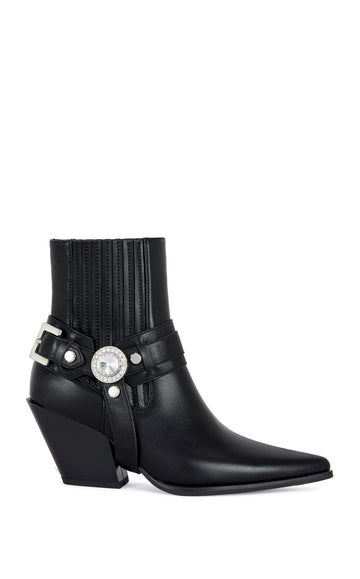 black faux leather ankle bootie with a pointed toe, block heel, and a belted accent on the upper with a chunky rhinestone embellishment