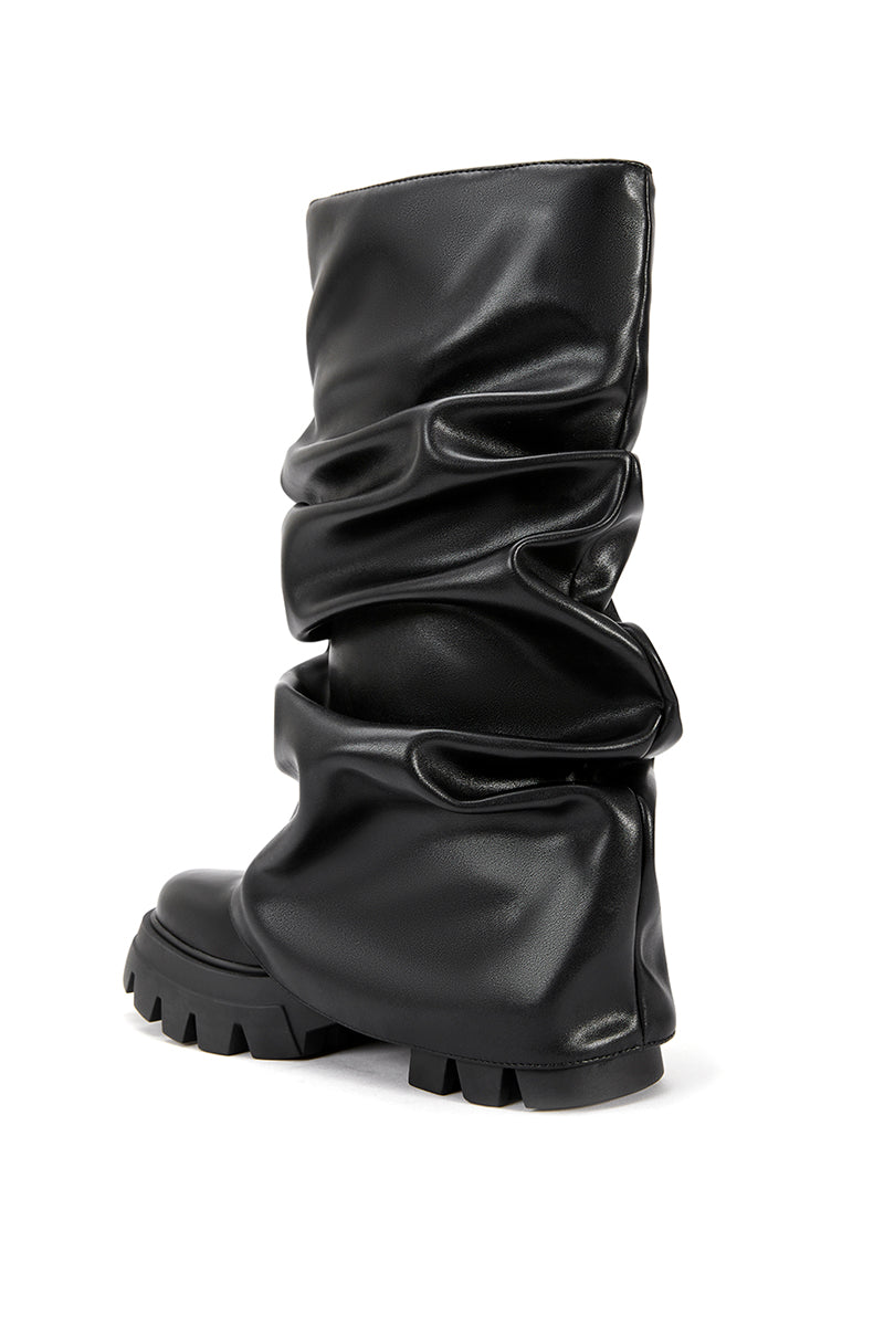 back view of black faux leather platform boots with a mid calf length and black fold over silhouette