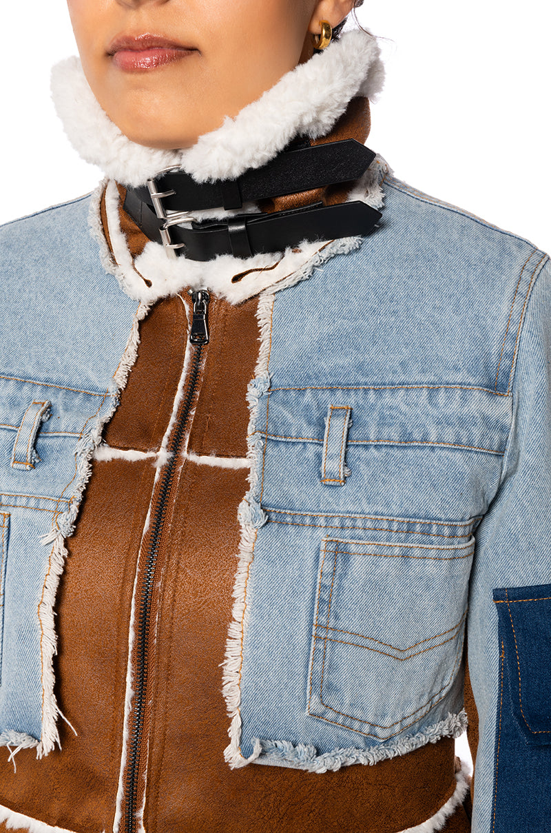 detail shot of asymmetric cut shearling jacket with denim jacket style sleeves and a shearling collar