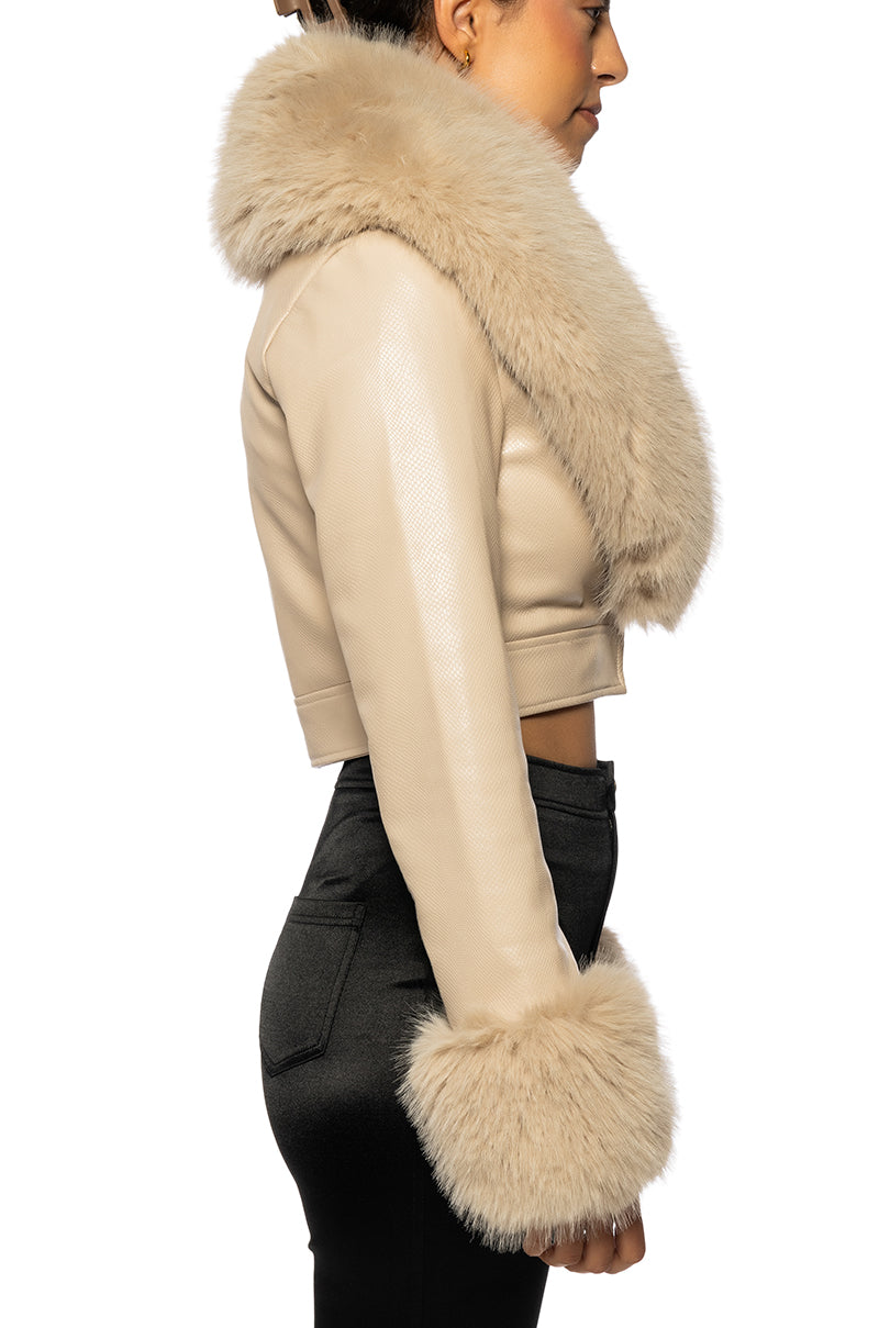 side view of Beige faux leather cropped jacked with a fluffy faux fur collar and faux fur sleeves