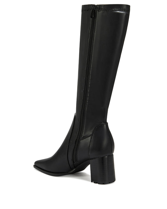 black faux leather knee high boots with a 4 way stretch shaft, a block heel, and a pointed toe silhouette