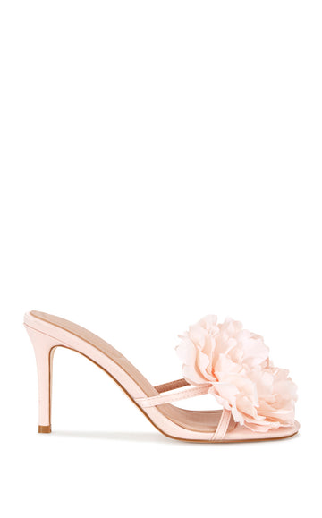 blush pink faux leather strappy stiletto heels with an open toe, slip on fit, and an oversized pink flower accent on the foot strap