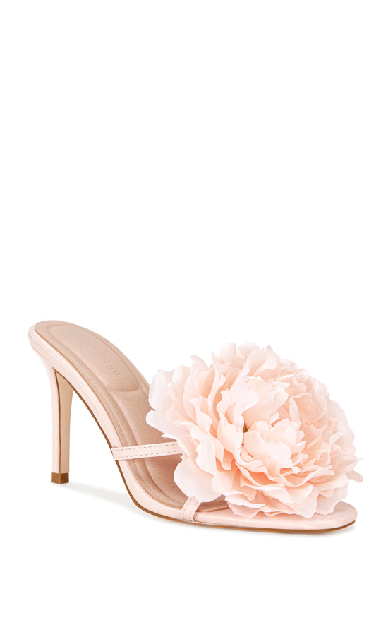 blush pink faux leather strappy stiletto heels with an open toe, slip on fit, and an oversized pink flower accent on the foot strap