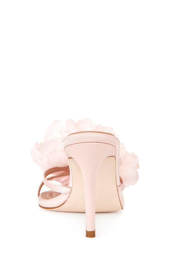 blush pink faux leather strappy stiletto heels with an open toe, slip on fit, and an oversized pink flower accent on the foot strap