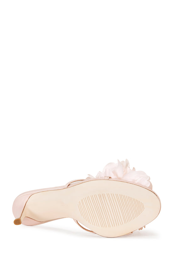 blush pink faux leather strappy stiletto heels with an open toe, slip on fit, and an oversized pink flower accent on the foot strap
