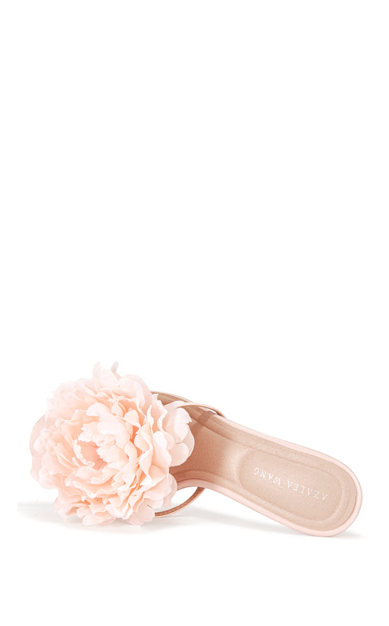 blush pink faux leather strappy stiletto heels with an open toe, slip on fit, and an oversized pink flower accent on the foot strap