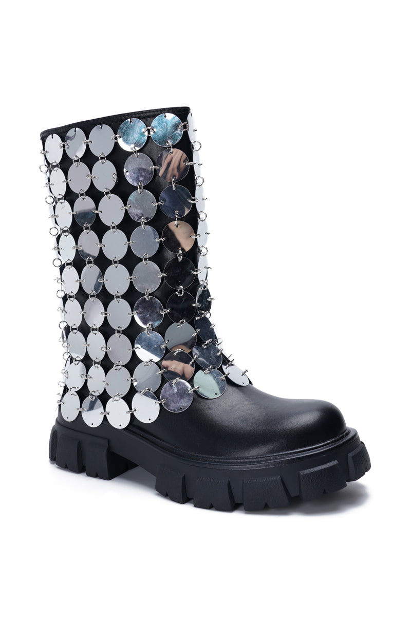 angled view of black platform boots with a metallic circular chainmail accent overlay