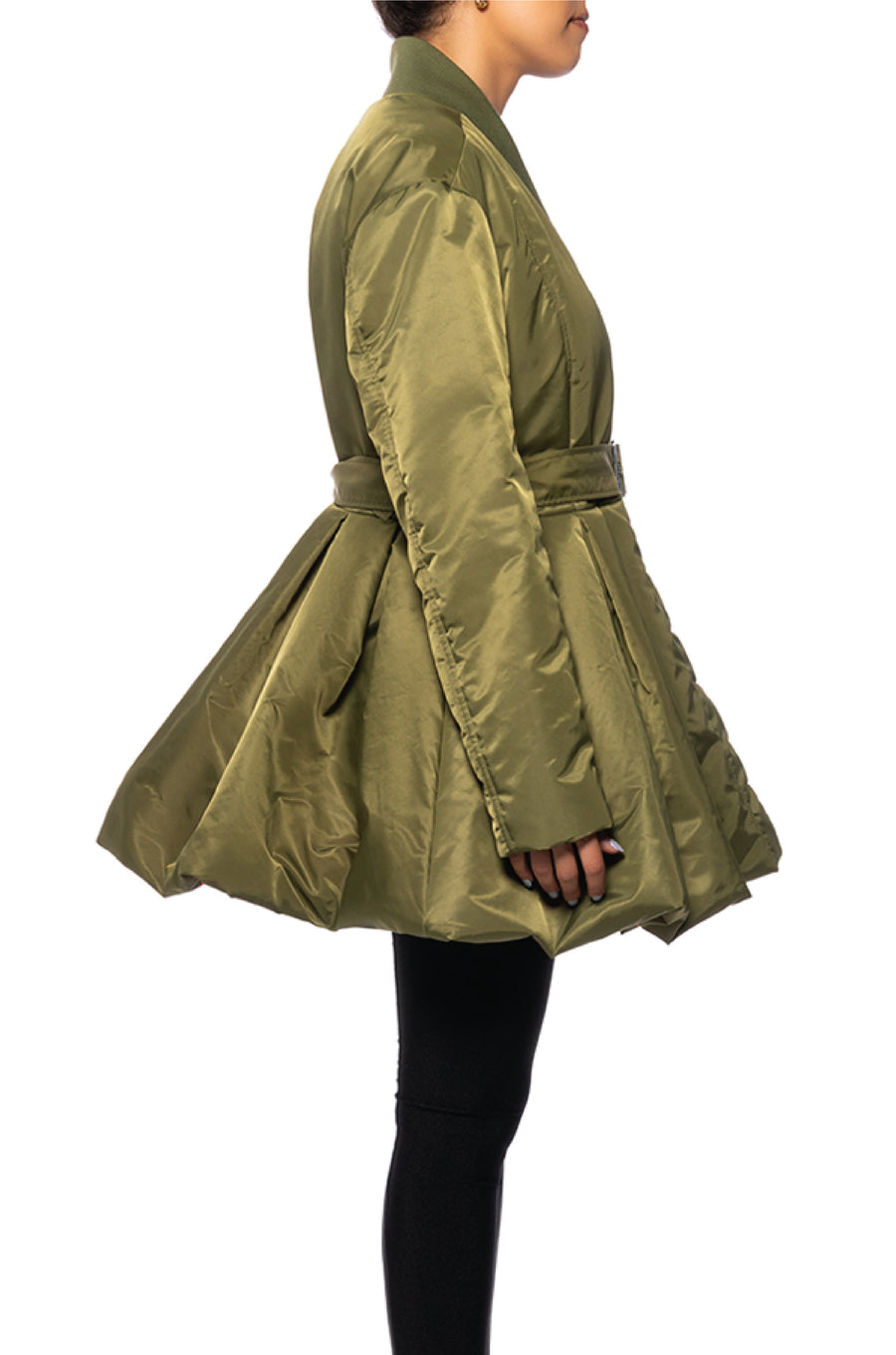 side view of olive green statement puffer jacket with a flared bottom and belt closure accent with an orange interior