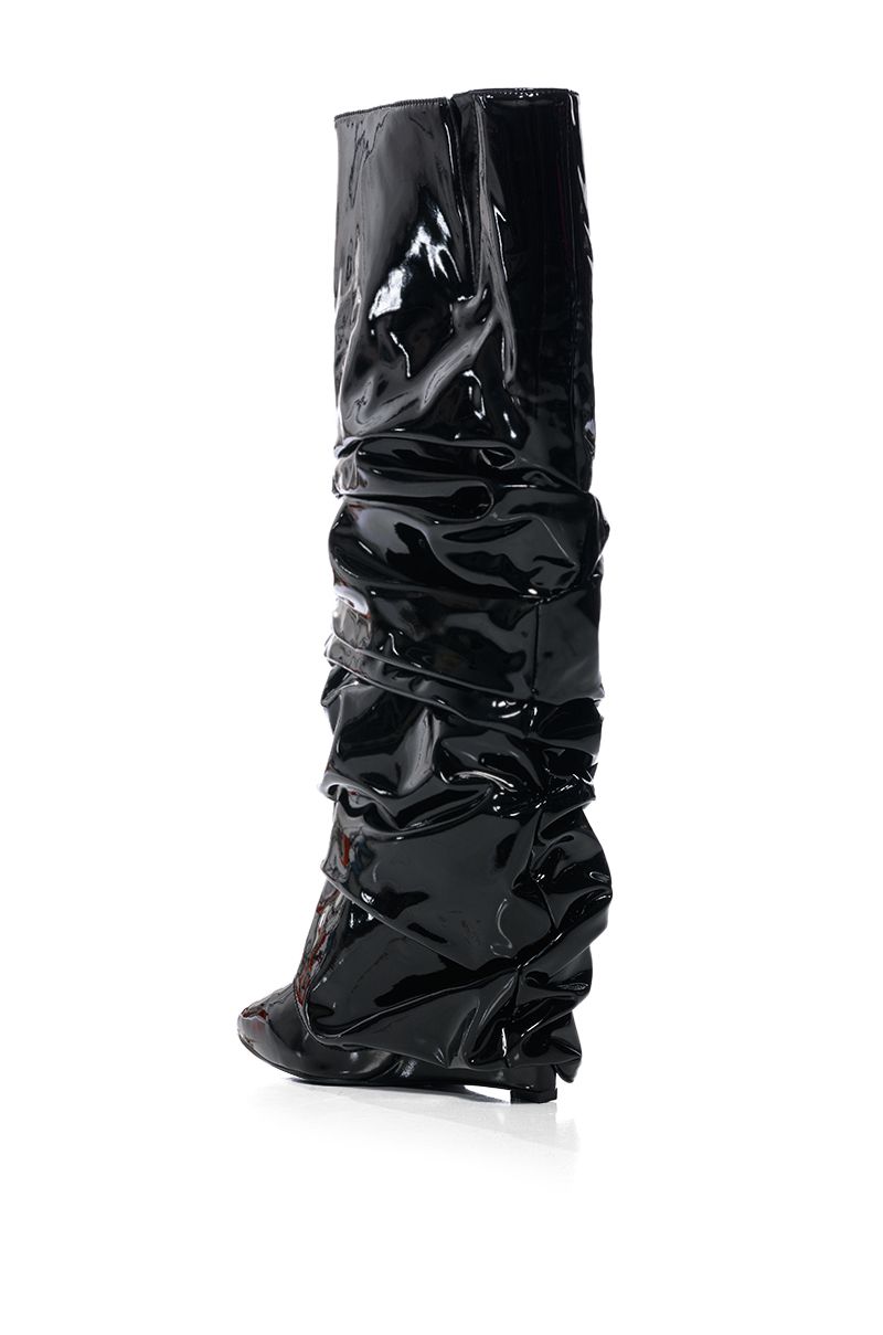 back view of shiny black patent faux leather wedge boots with a ruched detail and fold over silhouette